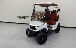 White 2025 Venom EV Strike 2-Passenger Golf Cart featuring 10" touchscreen, Apple CarPlay, custom stitched seats, 4-wheel disc brakes, and dual independent suspension